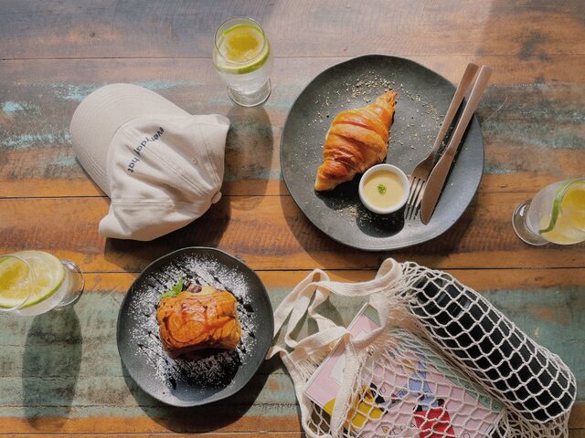 Boné sacola e pratos com pães em cima de mesa de madeira